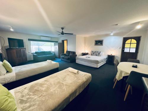 长滩港Beachport Motor Inn的一间带三张床的房间和一个带沙发的客厅