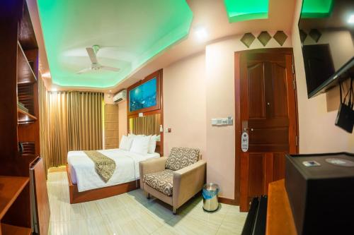 马累ZAN Lodge的配有一张床和一把椅子的酒店客房