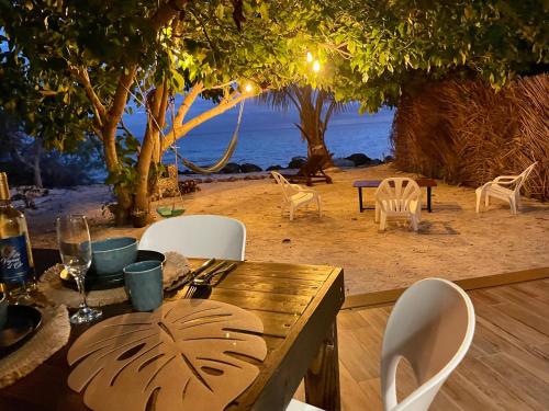 阿瓦托鲁Rangiroa Beach House的一张木制桌子和椅子,享有海滩美景