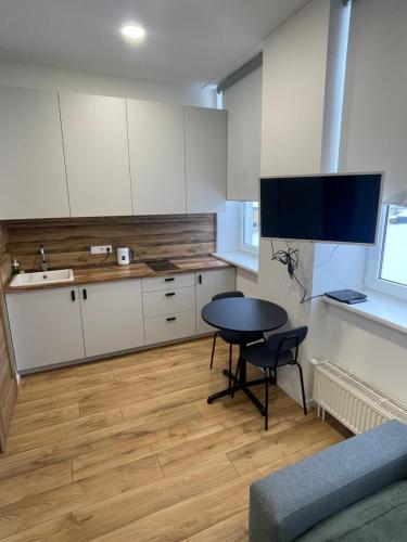 维尔纽斯Airport Apartment 32 self check-In Free Parking的厨房配有白色橱柜、桌子和水槽。