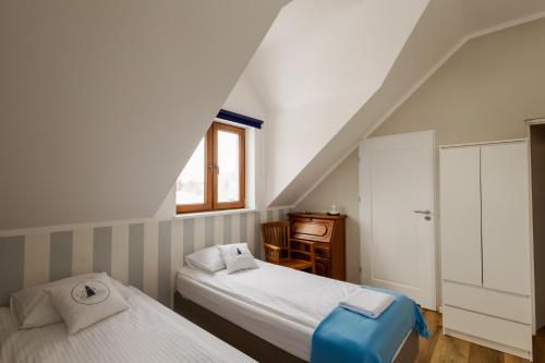文戈热沃Czar Mamry Apartamenty的一间卧室设有两张床、一张桌子和一个窗口。