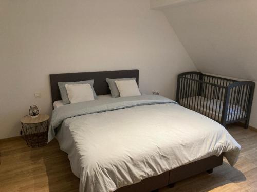 迪克斯梅德EN PASSANT appartement的一间卧室配有一张大床和一张婴儿床