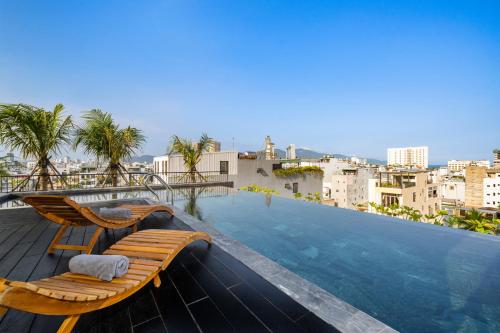 岘港Thè HEM Hotel and Apartment的一座建筑物屋顶上带躺椅的游泳池
