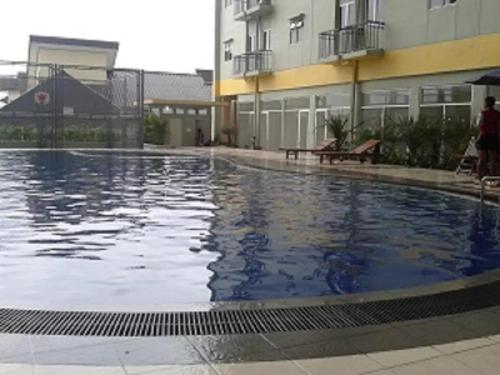 万隆Metro Suits Apartment Bandung的大楼前的大型游泳池