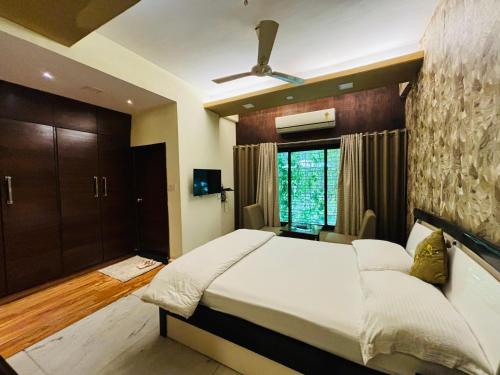 那格浦尔Royal Palms Luxury Service Apartment的一间卧室设有一张大床和一个窗户。