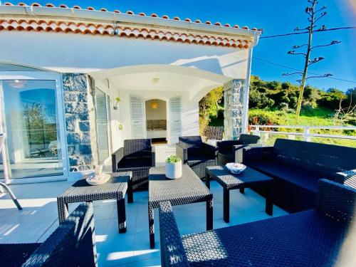 卡尔热斯Villa Montalbo vue mer de 2 à 10 personnes的天井配有沙发和桌椅
