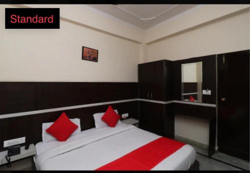 哈里瓦hotel dreamland的一间卧室配有一张带红色枕头的大床