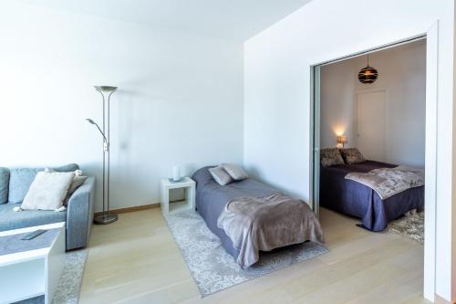 汉科Regatta Seaside Suite in Hanko的一间带镜子、一张床和一张沙发的卧室
