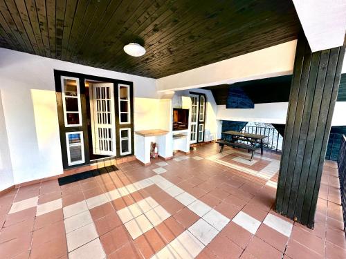普雷代亚尔Pine Peak Apartments的客厅设有木制天花板和瓷砖地板。