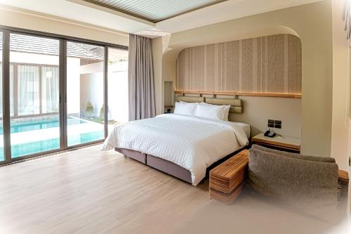 查汶Baan Haad Ngam Boutique Resort的一间卧室设有一张床和一个游泳池