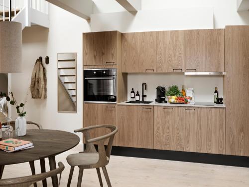 奥胡斯Aura Apartment Hotel的厨房配有木制橱柜和桌子