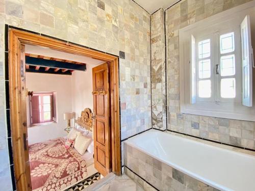 突尼斯Lella Khadija B&B Sidi bou said的带浴缸的浴室和窗户。