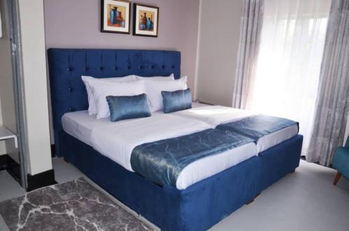AruaRX Suites的卧室内的一张蓝色床和两个蓝色枕头