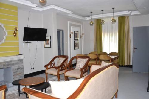 AruaRX Suites的客厅配有桌椅和电视。