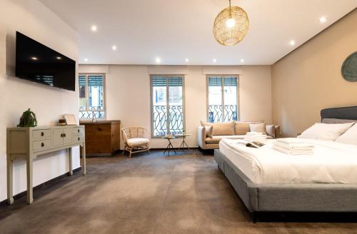 特拉维夫Jaffa Port TLV Hotel Apartments יפו תל אביב的一间卧室配有一张床、一张沙发和窗户。