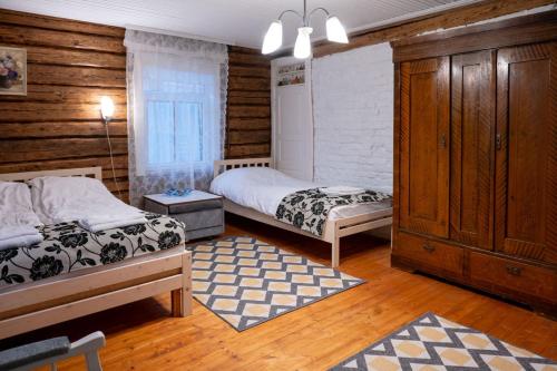 UrvasteUrvaste Vana-Söödi Puhkemaja的木墙客房的两张床
