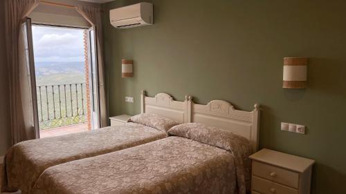 拉伊鲁埃拉芬卡梅赛德斯酒店的卧室设有两张床和大窗户