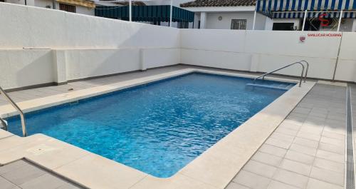 桑卢卡尔-德巴拉梅达Arenas de Doñana amplio apartamento frente del mar的一座大楼顶部的游泳池