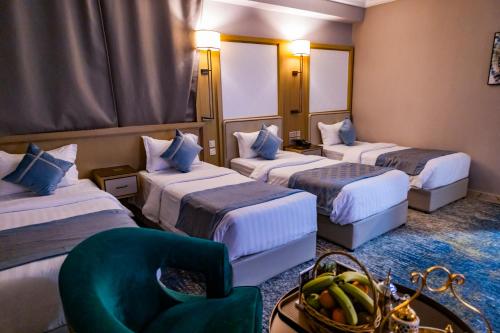麦地那فندق وقف عثمان بن عفان的酒店客房,设有三张床和椅子