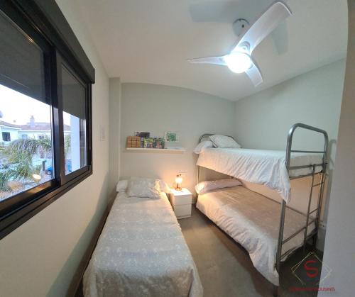 桑卢卡尔-德巴拉梅达Arenas de Doñana amplio apartamento frente del mar的一间卧室设有两张双层床和一扇窗户。