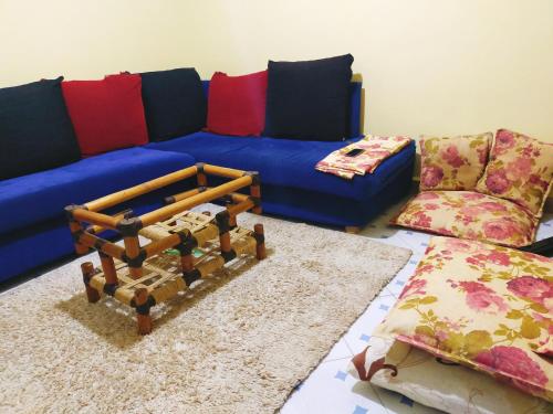 MasenoGill's Crib的客厅配有蓝色的沙发和地毯。