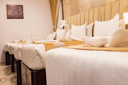 麦地那最好的麦地那酒店的房间里的一排白色的床