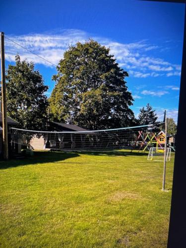 梅恩塞尔斯Trommeļa brīvdienu mājiņas-kempings的草地上一个设有排球网的公园