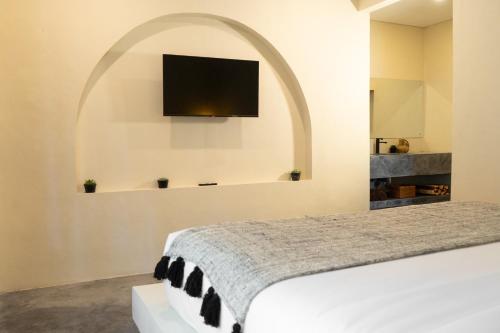 乌布Savanna Ubud的卧室配有一张床铺,墙上配有电视