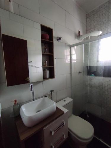 瓜皮米林Casa 2 qtos, sendo suíte com cama Queen ar condicionado的浴室配有卫生间、盥洗盆和淋浴。