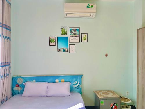 潘切Lộc Vừng Homestay的卧室配有一张蓝色的床,墙上挂有图片