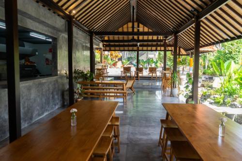 乌布Savanna Ubud的餐厅设有木桌和木椅