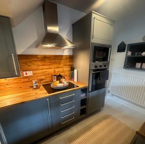 亚伦桥Airthrey Cottage的厨房配有不锈钢用具和木台面