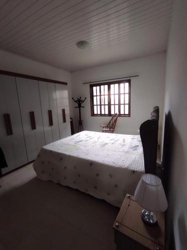 瓜皮米林Casa 2 qtos, sendo suíte com cama Queen ar condicionado的一间卧室设有一张大床和一个窗户。