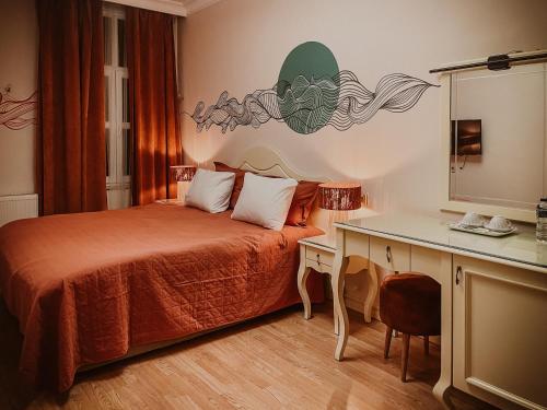 伊斯坦布尔Dervish Han Boutique Hotel的一间卧室配有一张床和一张带镜子的书桌