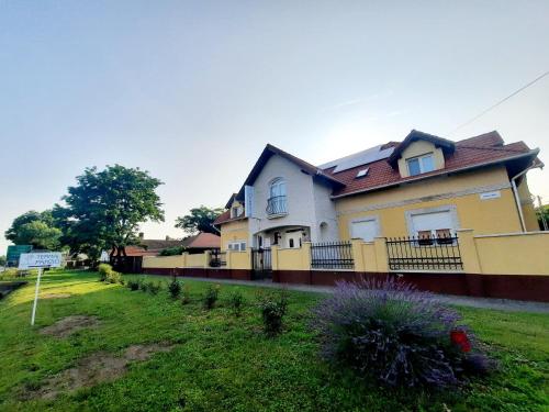 豪伊杜纳纳什Sóvirág Termál Panzió的院子中带围栏的黄色房子