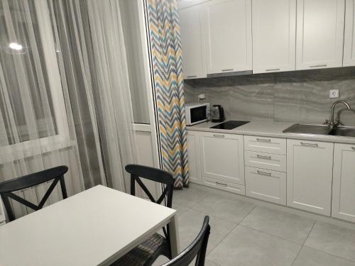 Alghabas2-я квартира Алматы Арена ЖК的厨房配有白色橱柜和桌椅