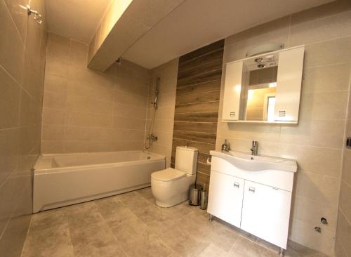 塞尔丘克Efes Hidden Garden Resort Otel的带浴缸、卫生间和盥洗盆的浴室