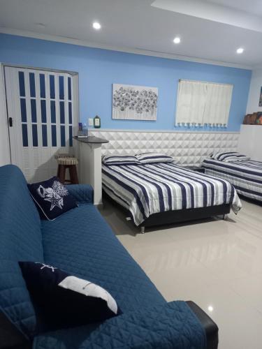 圣安德烈斯Holiday Loft Suite Apartamento的卧室设有两张床铺和蓝色的墙壁