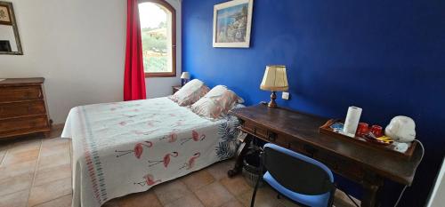 滨海圣西尔B&B Sita chambres d'hotes的一间卧室配有一张床和一张带台灯的书桌