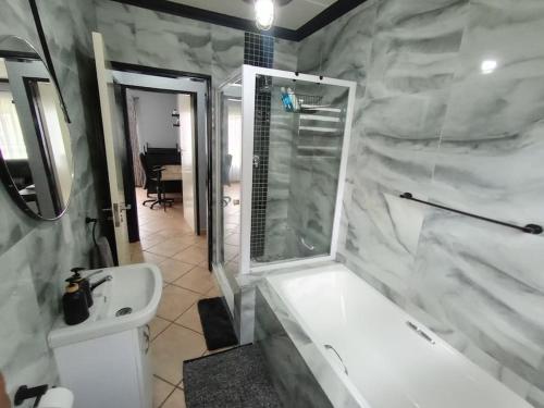 博克斯堡Maneli 69的浴室配有白色浴缸和水槽