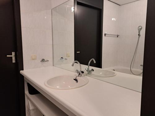 玛库姆Zuiderzeestate 35, prachtig appartement aan het IJsselmeer的白色的浴室设有水槽和淋浴。