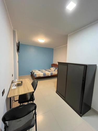 塔拉拉Condominio Confortable的一间带桌椅的房间和一间带床的房间