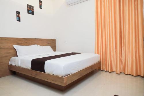 PayyannūrComfort INN的卧室内的一张床位,配有橙色窗帘