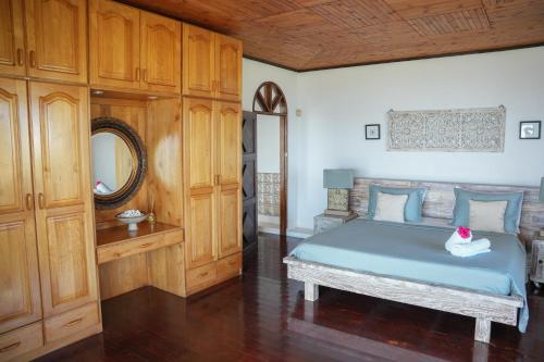 马埃岛Beau Soleil Stunning Sea View One Bedroom Apartment的一间卧室配有蓝色的床和镜子