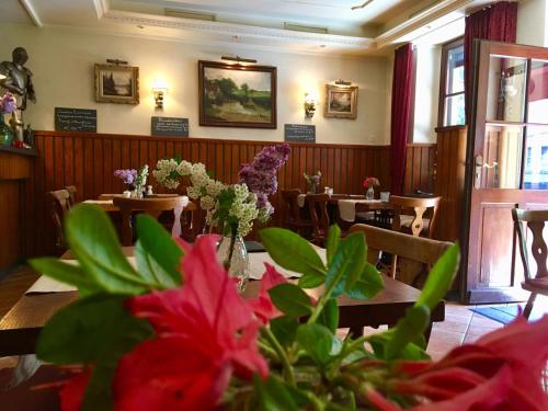 博福特Hotel Auberge Rustique的餐厅内带桌子和鲜花的用餐室