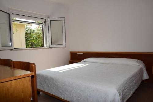 维耶斯泰Pellegrino Village的卧室配有白色的床和窗户。