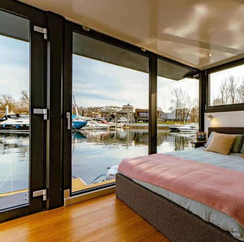 安杰拉Sopra l'acqua - Houseboat的卧室设有大窗户,享有码头的景色