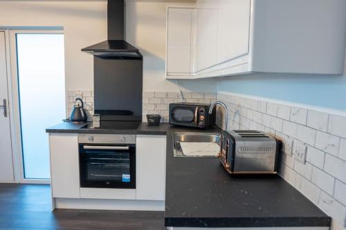 爱丁堡The Beach House的厨房配有炉灶和台面上的烤面包机