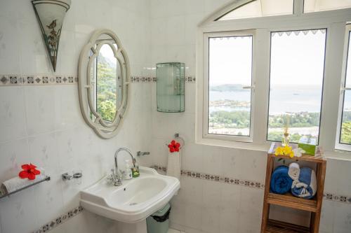 马埃岛Beau Soleil Stunning Sea View One Bedroom Apartment的白色浴室设有水槽和2扇窗户