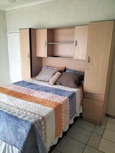 彼得马里茨堡Restwell Accommodation的一间卧室配有一张大床和一个橱柜